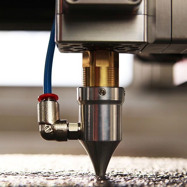 Close-up of a precision laser cutting machine nozzle in action, showcasing high-tech equipment used in professional laser cutting services.