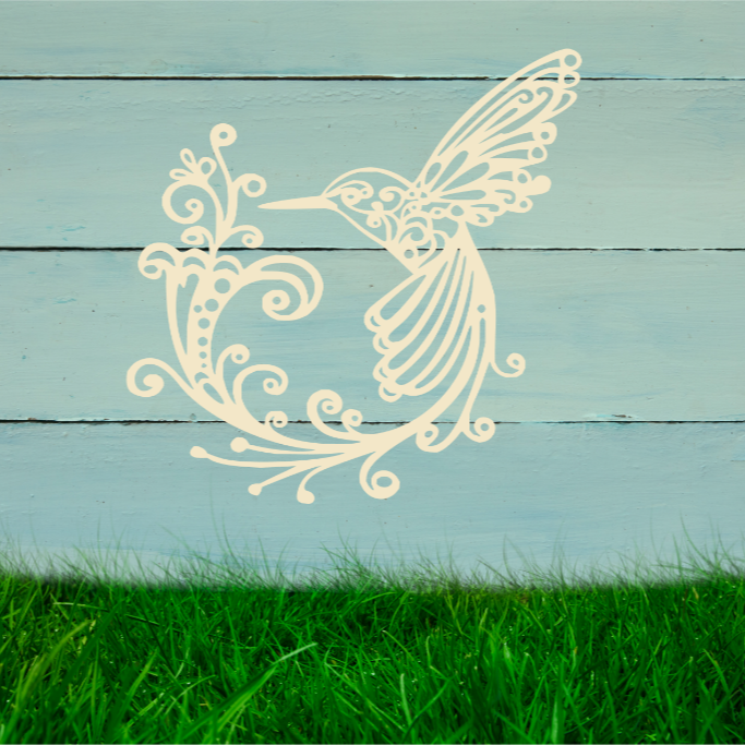 Delicate metal wall art featuring a hummingbird with intricately detailed wings and tail, surrounded by swirling vine patterns, finished in Canola Cream powder coating, mounted on a rustic white wooden backdrop, perfect for adding a touch of nature to an outdoor space.