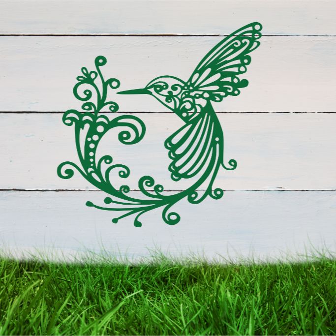 Delicate metal wall art featuring a hummingbird with intricately detailed wings and tail, surrounded by swirling vine patterns, finished in Mistletoe powder coating, mounted on a rustic white wooden backdrop, perfect for adding a touch of nature to an outdoor space.