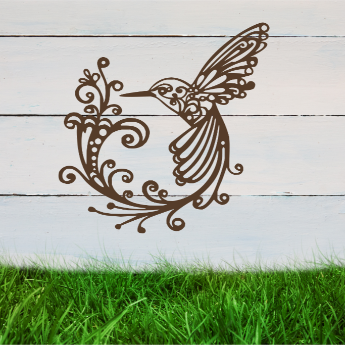 Delicate metal wall art featuring a hummingbird with intricately detailed wings and tail, surrounded by swirling vine patterns, finished in Rust Patina powder coating, mounted on a rustic white wooden backdrop, perfect for adding a touch of nature to an outdoor space.